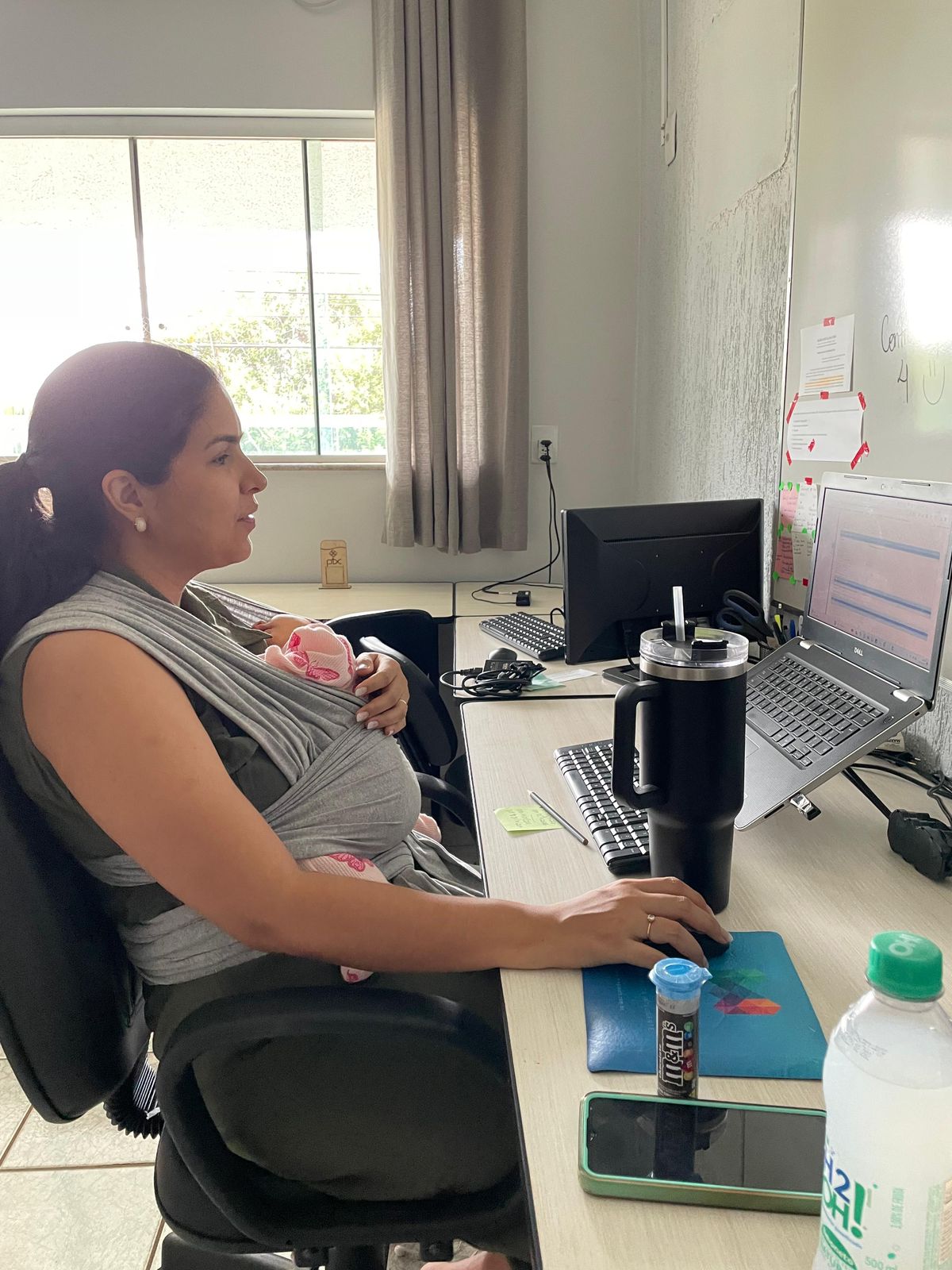 Amanda trabalhando com sua filha Cecília no colo